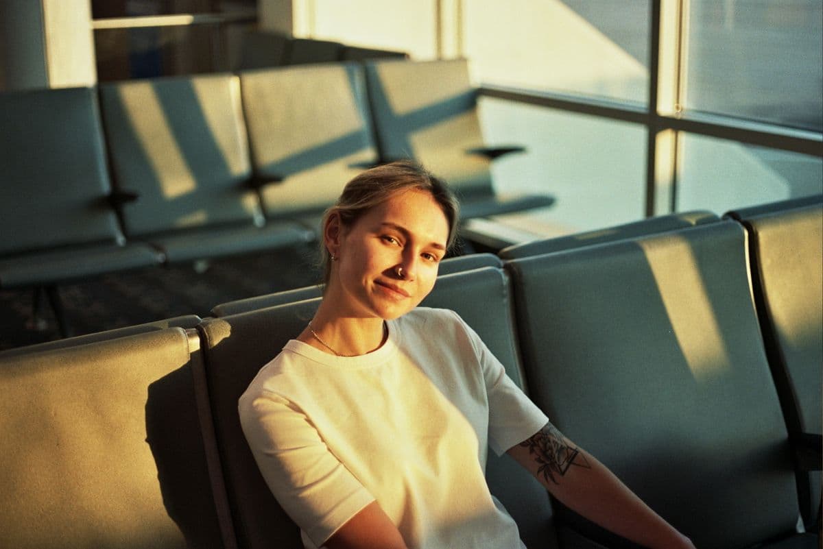 Relaxed traveller sitting in a sunlit airport departure lounge